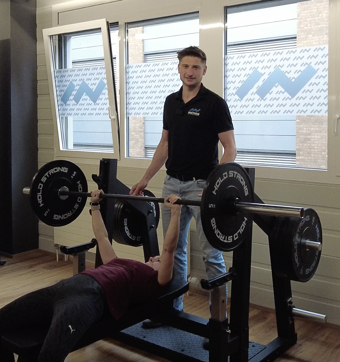 Qualicert zertifizierter Physioexperte mit Fitnessausbildung trainiert Kunde